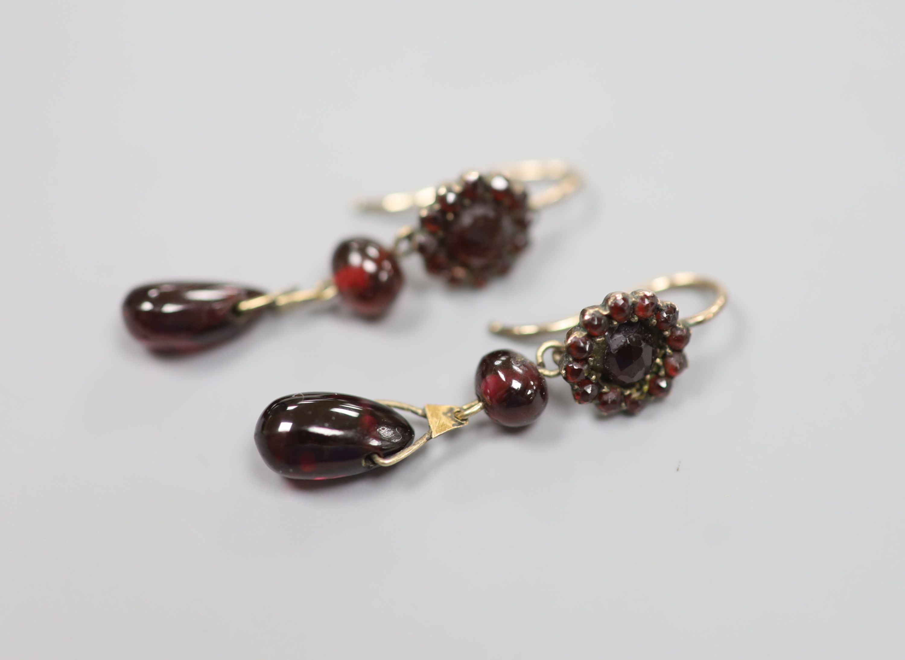A pair of late Victorian gilt white metal?, facet, bead and pear shaped garnet set drop earrings
